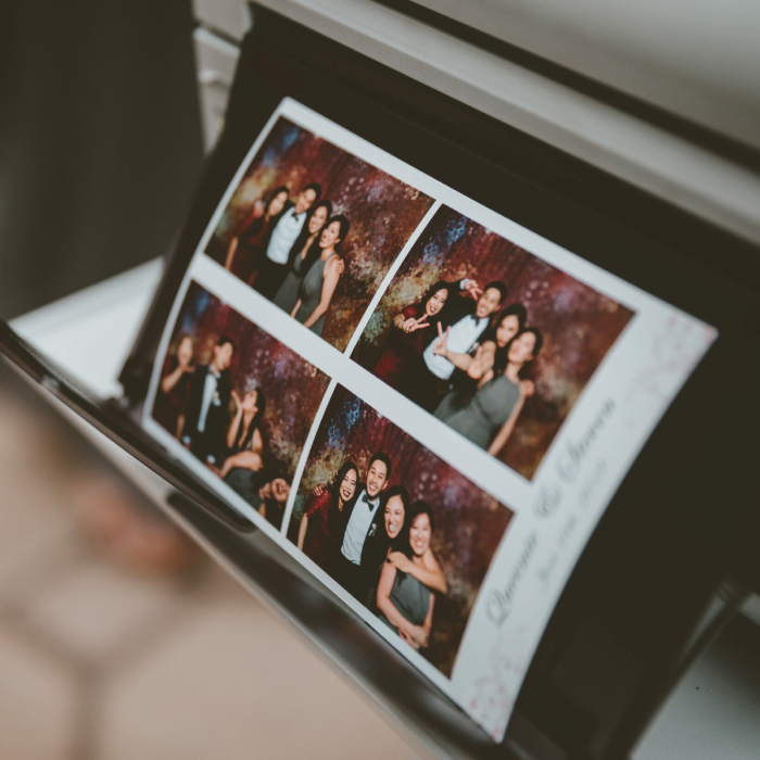 Guests receiving printed photo booth strips